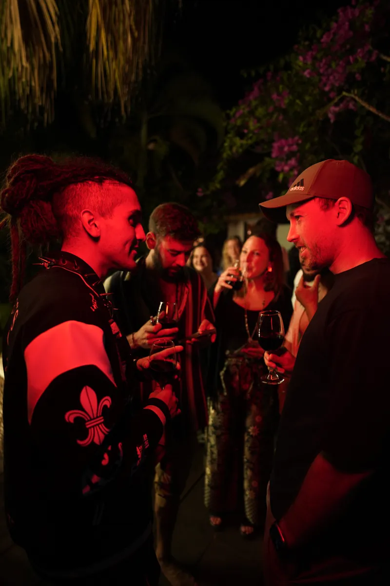 Guests in conversation over wine at a night garden party