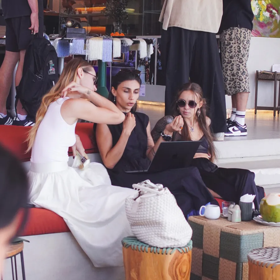 Members working together over laptops at a poolside café